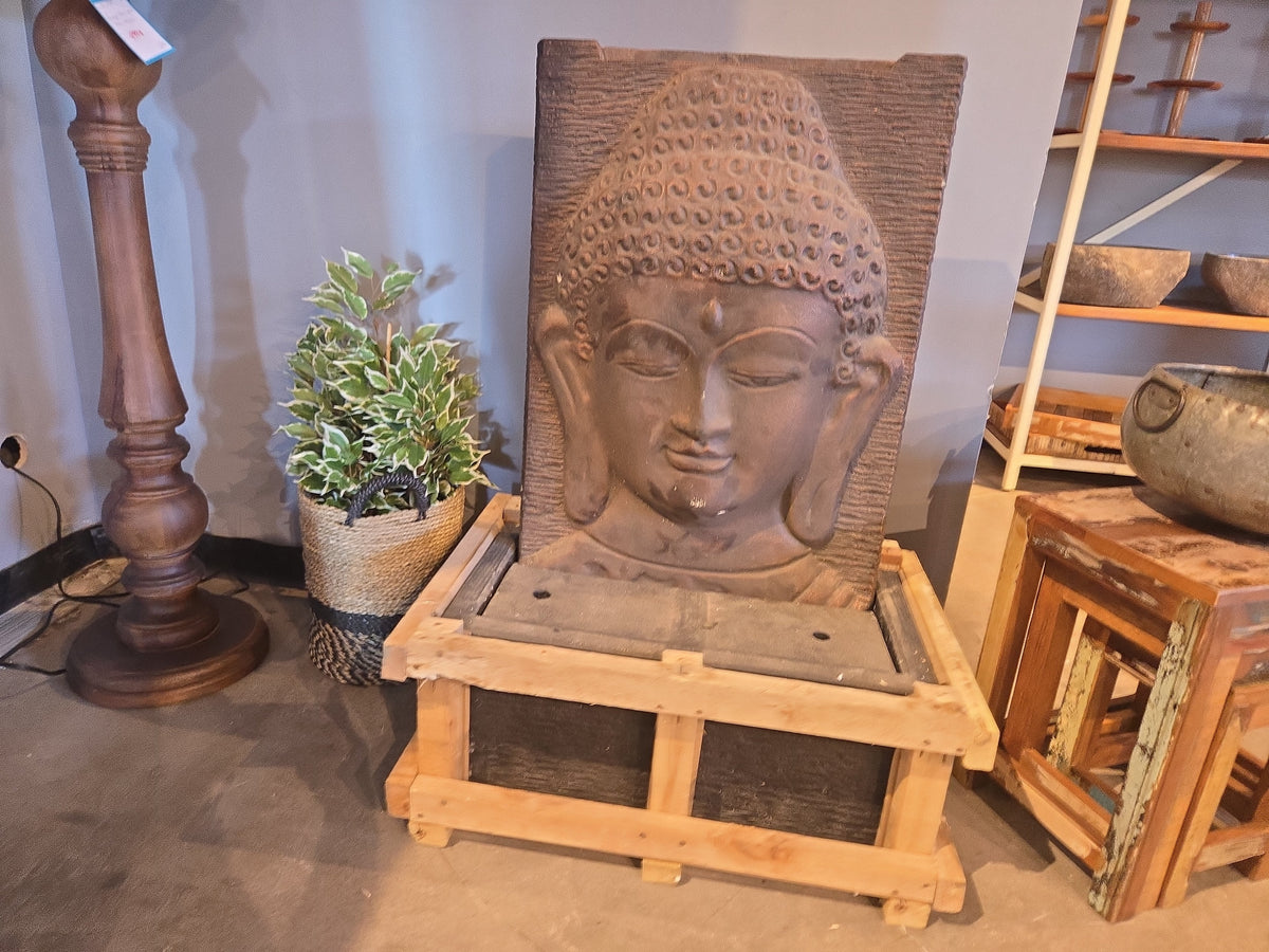 Sand-toned Buddha fountain in store, sitting on its shipping crate