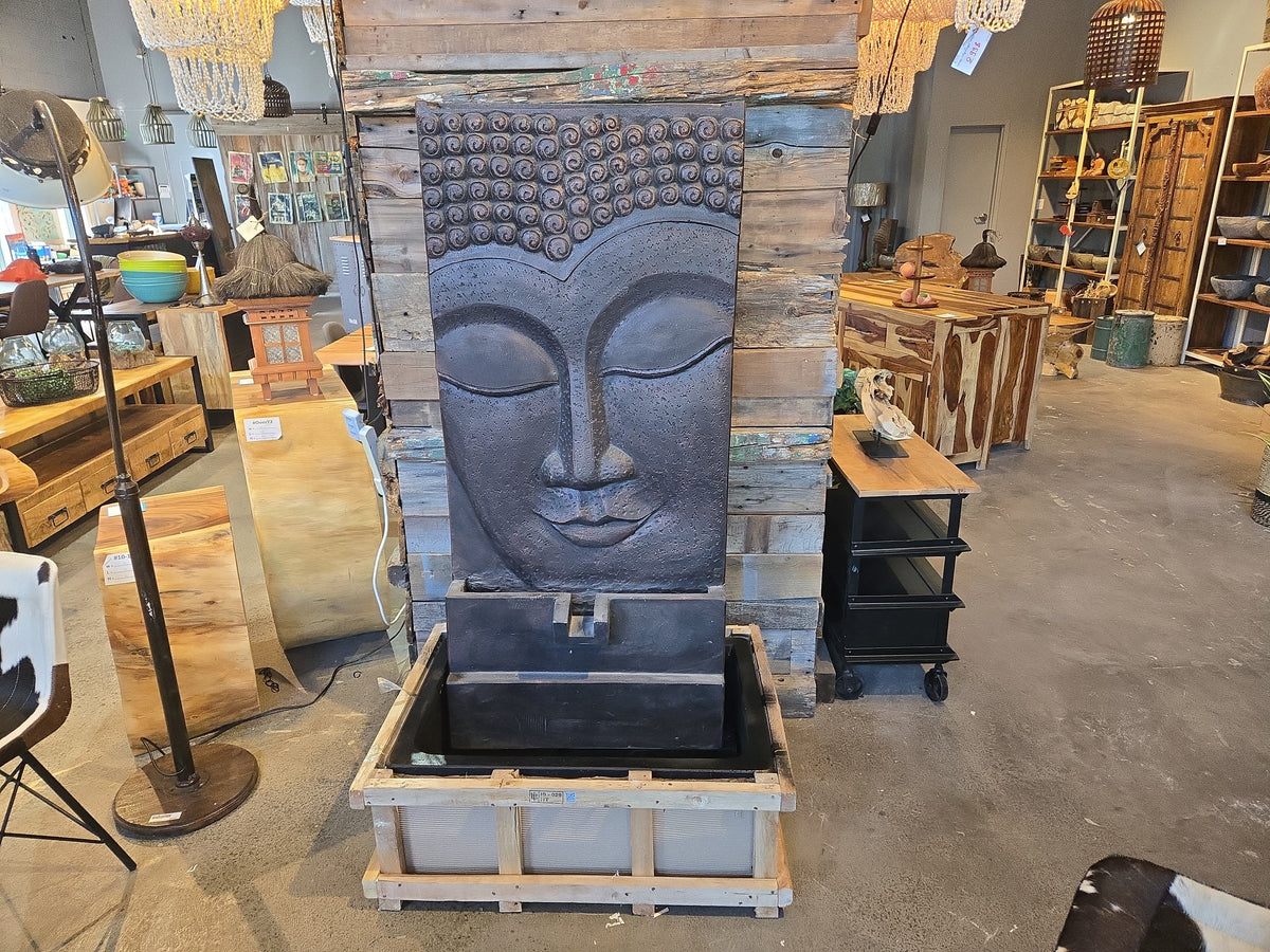 Large dark grey Buddha fountain in store, sitting on its shipping crate