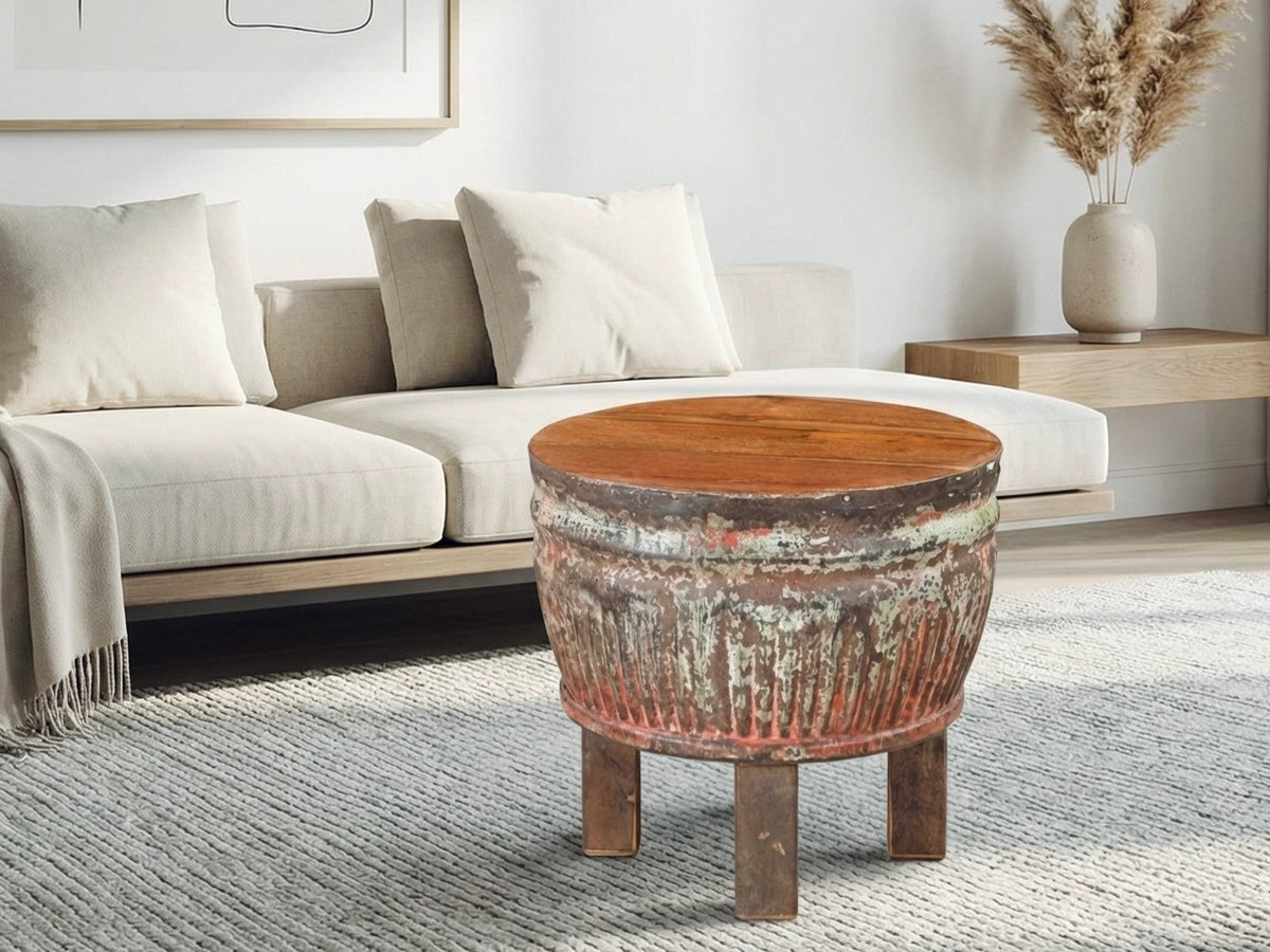 Table à café ronde Hubli en teck, plateau épais sur base sculptée, dans un salon