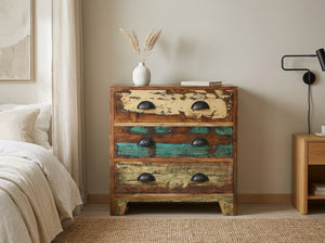 Three-drawer reclaimed wood nightstand painted cream, turquoise and green, in a bedroom