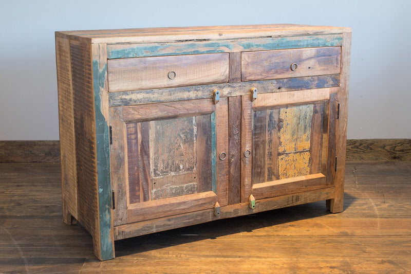 Cabinet en bois recyclé multicolore vu de trois quarts, deux tiroirs au-dessus de deux portes