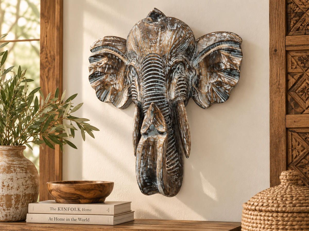 Tête d'éléphant en bois sculpté accrochée à un mur, au fini blanchi
